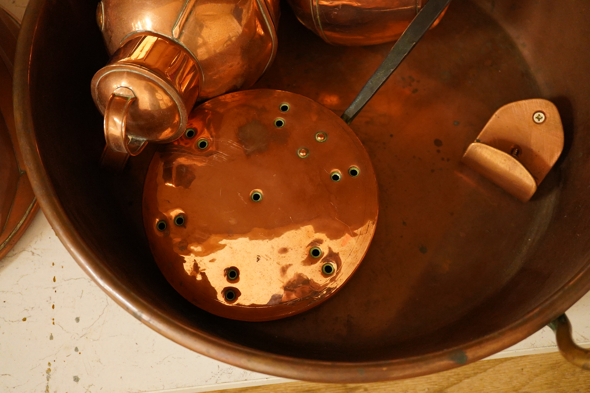 Five copper items including a large jelly mould, a two handled pan, two jugs and a chestnut roaster, pan 41cm diameter. Condition - fair to good